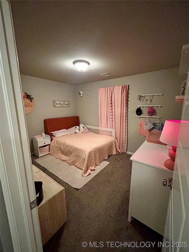 bedroom with dark colored carpet and visible vents