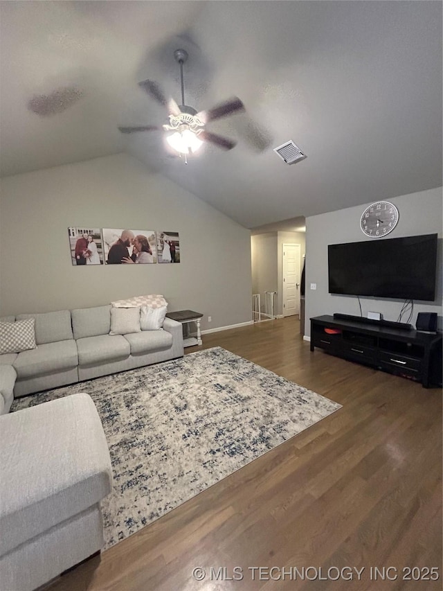 living area with visible vents, ceiling fan, baseboards, lofted ceiling, and wood finished floors