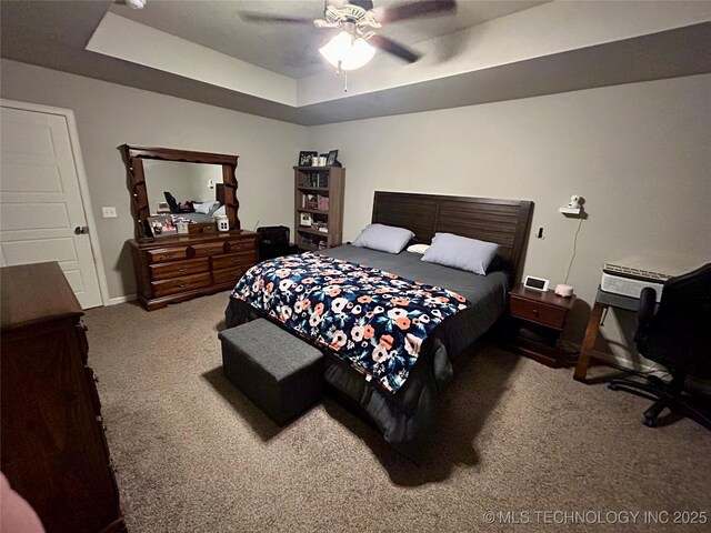 bedroom with a tray ceiling, baseboards, carpet, and ceiling fan