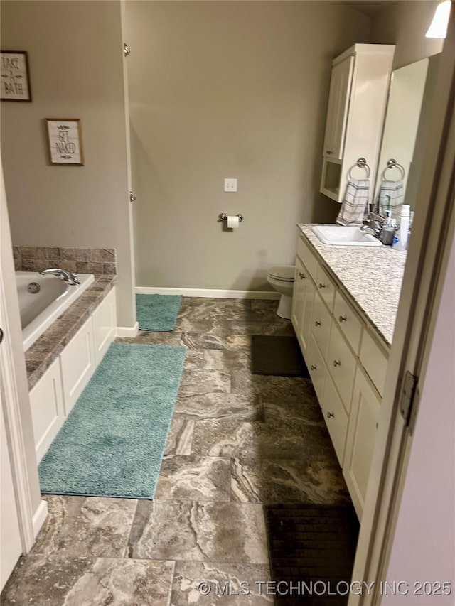 full bathroom featuring baseboards, toilet, a bath, and vanity