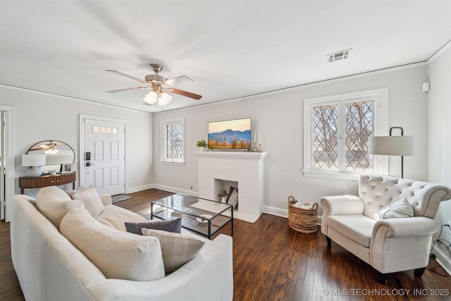 living area with visible vents, a brick fireplace, dark wood-type flooring, and baseboards