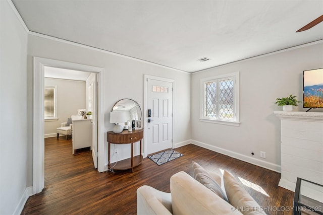 interior space featuring crown molding, dark wood-style floors, baseboards, and visible vents