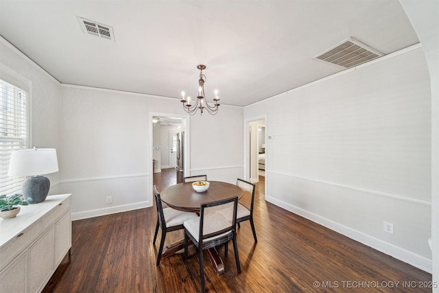 dining space featuring dark wood-style floors, visible vents, baseboards, and an inviting chandelier