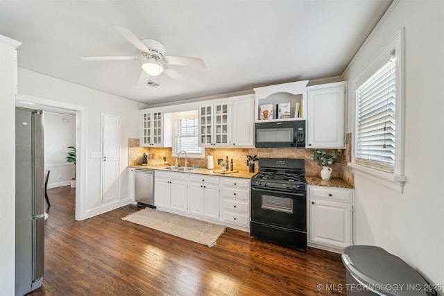 kitchen with black appliances, a sink, backsplash, dark wood finished floors, and white cabinetry