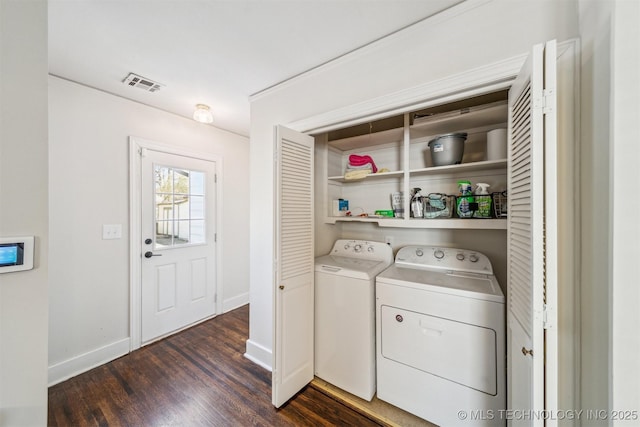 laundry area with visible vents, dark wood-style floors, separate washer and dryer, baseboards, and laundry area