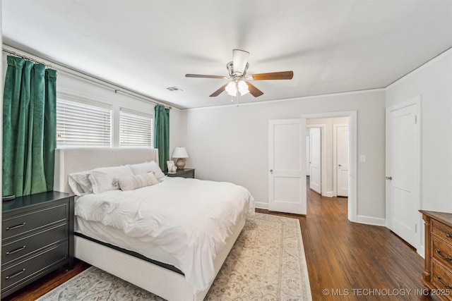 bedroom with visible vents, crown molding, baseboards, dark wood-style floors, and a ceiling fan