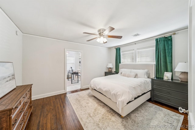 bedroom featuring visible vents, dark wood-type flooring, a ceiling fan, crown molding, and baseboards