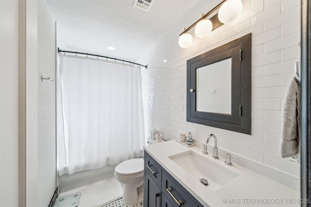 bathroom with visible vents, toilet, vanity, decorative backsplash, and tile walls