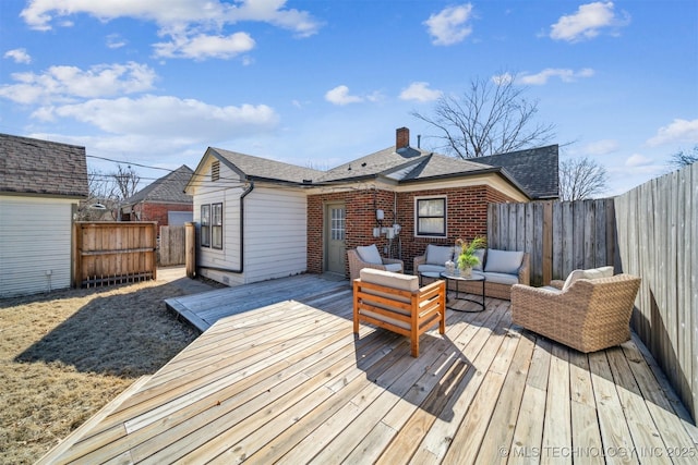 wooden terrace with outdoor lounge area and a fenced backyard