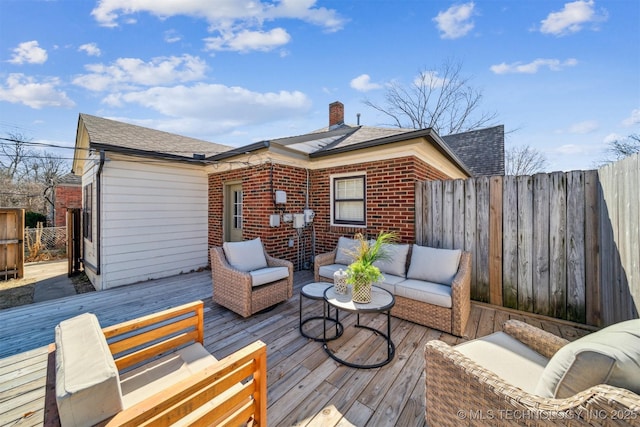 wooden deck featuring an outdoor hangout area and fence