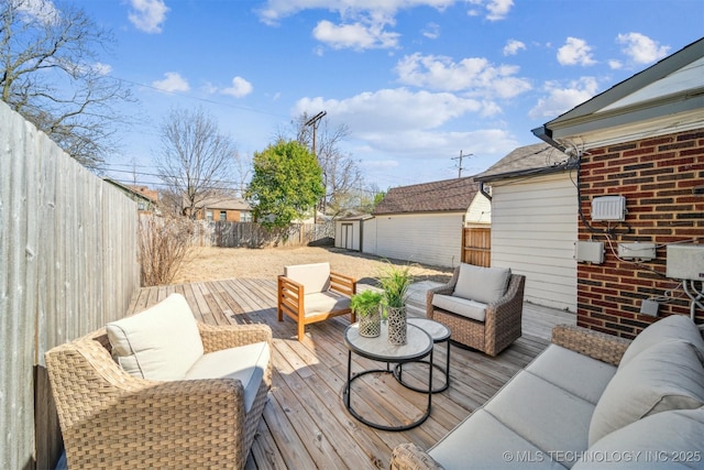 deck featuring outdoor lounge area, an outdoor structure, and a fenced backyard