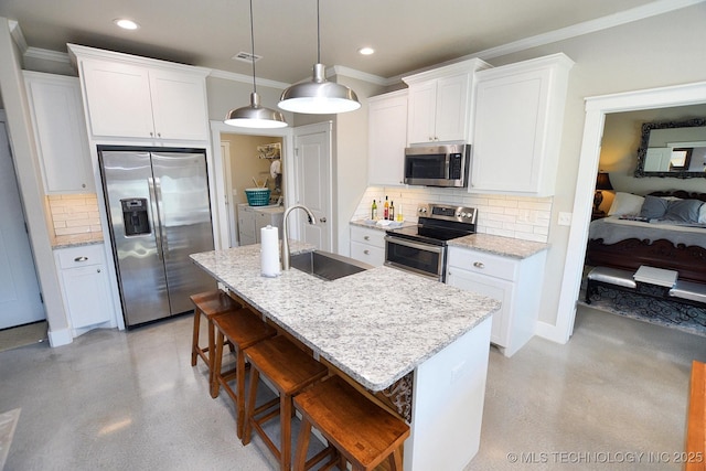 kitchen featuring finished concrete floors, appliances with stainless steel finishes, a breakfast bar, and a sink