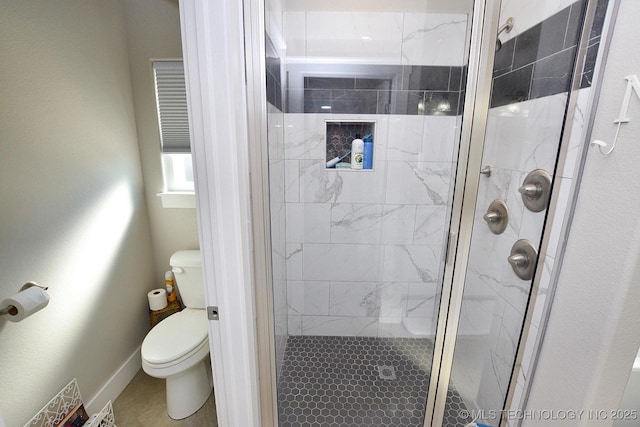 full bathroom with a shower stall, toilet, and baseboards