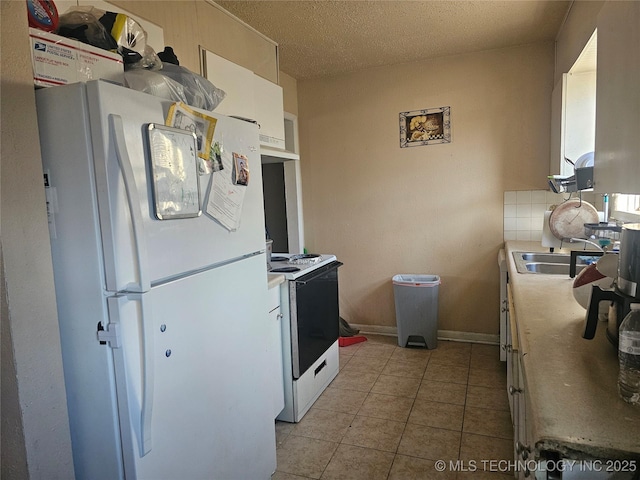 kitchen featuring under cabinet range hood, tasteful backsplash, white appliances, light tile patterned floors, and baseboards