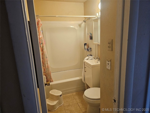 bathroom featuring tile patterned flooring, toilet, shower / tub combo with curtain, a textured wall, and vanity