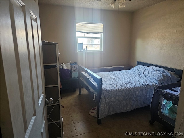 tiled bedroom with a textured ceiling