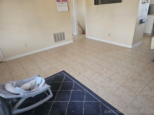 spare room with baseboards and visible vents