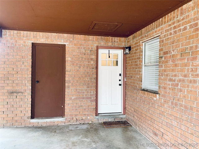 property entrance featuring brick siding