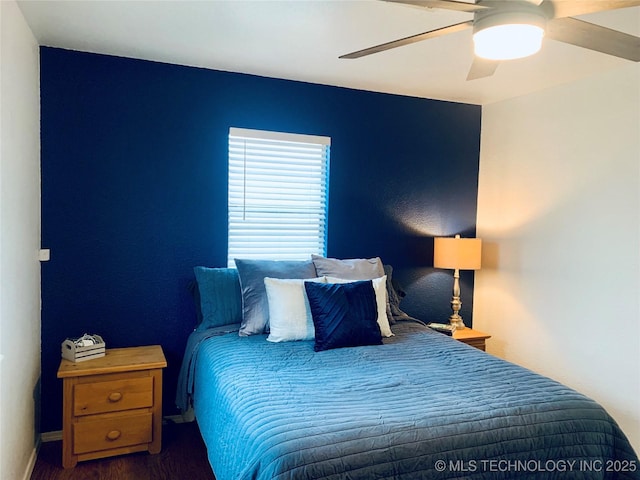 bedroom featuring baseboards, wood finished floors, and ceiling fan