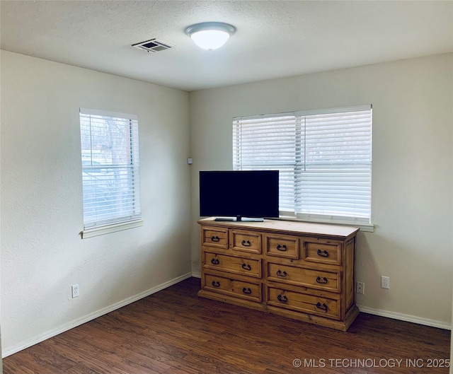 bedroom featuring visible vents, baseboards, a textured ceiling, and dark wood finished floors