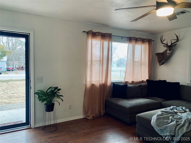 living room featuring wood finished floors, visible vents, and a healthy amount of sunlight