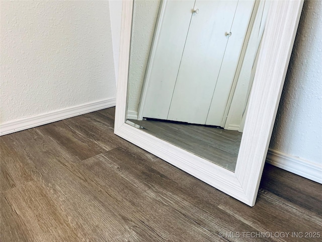 details featuring wood finished floors, baseboards, and a textured wall