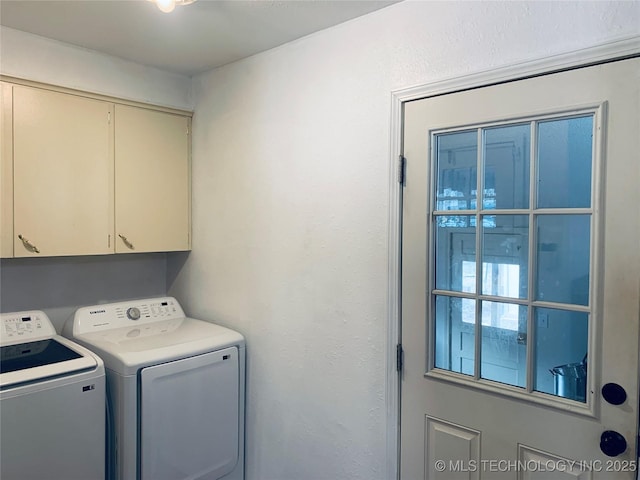 washroom featuring cabinet space and separate washer and dryer