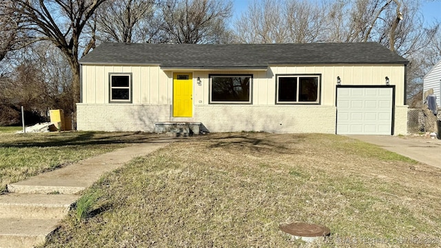 view of front of property with brick siding, a shingled roof, a front lawn, driveway, and an attached garage