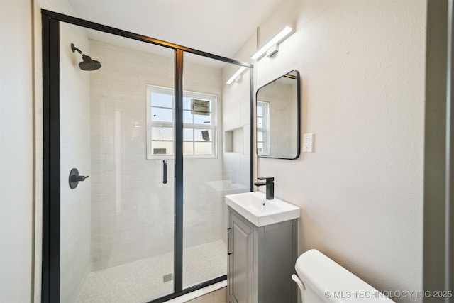 bathroom with vanity, toilet, and a stall shower