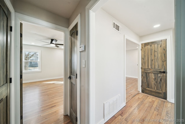 hallway with recessed lighting, visible vents, baseboards, and light wood-style floors