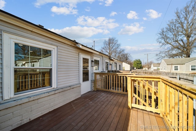 wooden terrace featuring a residential view and fence