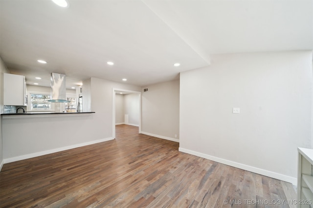 unfurnished living room featuring visible vents, recessed lighting, baseboards, and wood finished floors