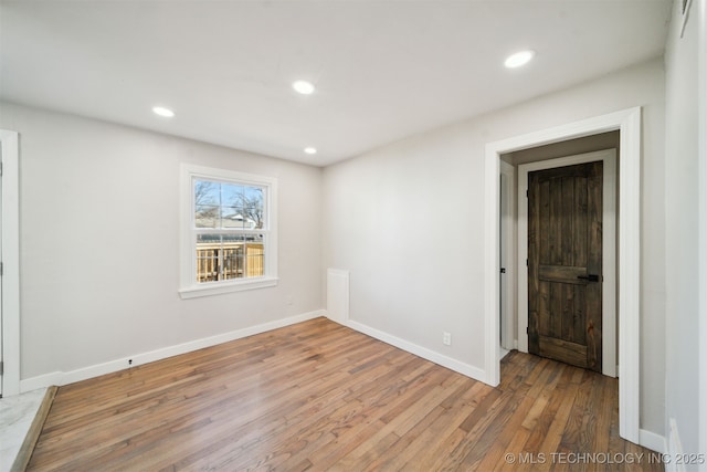 spare room featuring recessed lighting, baseboards, and light wood-style flooring