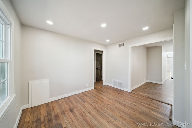 spare room featuring recessed lighting, visible vents, baseboards, and wood finished floors