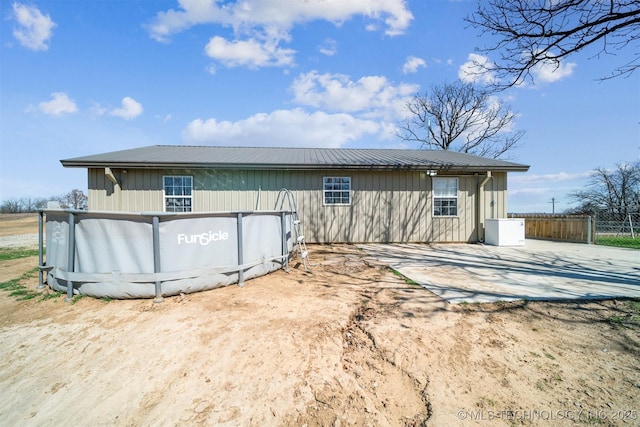 exterior space featuring metal roof and fence