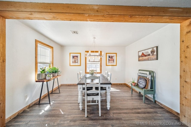 dining room featuring wood finished floors, visible vents, baseboards, beam ceiling, and a chandelier