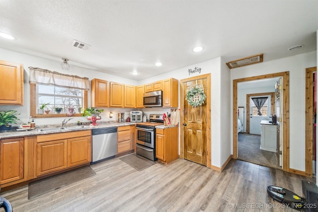 kitchen with visible vents, a healthy amount of sunlight, appliances with stainless steel finishes, and a sink