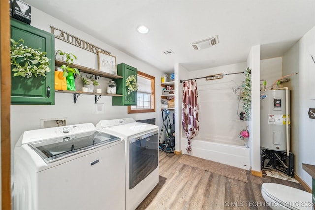 laundry area featuring visible vents, electric water heater, laundry area, light wood-style floors, and washer and dryer