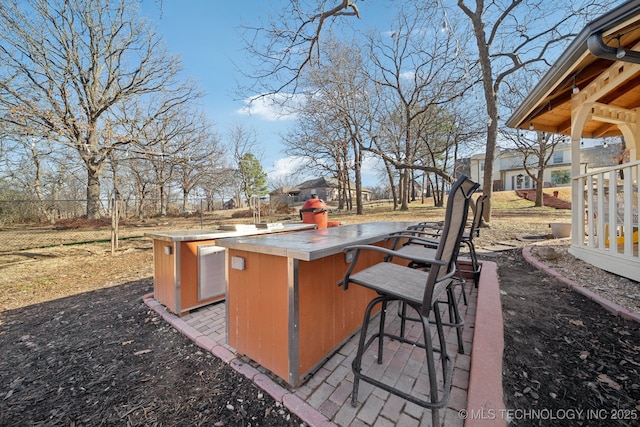 view of patio / terrace with area for grilling, outdoor wet bar, and fence