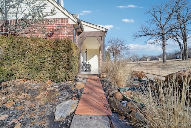 entrance to property featuring brick siding