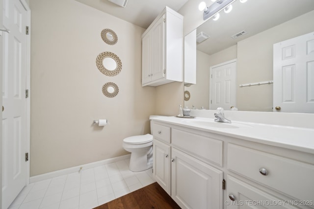 bathroom featuring visible vents, baseboards, toilet, and vanity