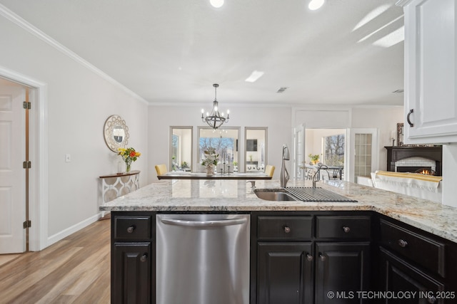 kitchen with dishwasher, dark cabinetry, ornamental molding, and a chandelier