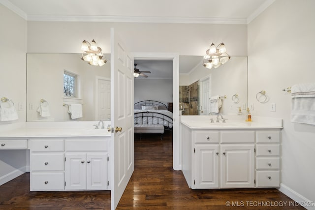 ensuite bathroom featuring wood finished floors, ensuite bath, two vanities, a sink, and crown molding