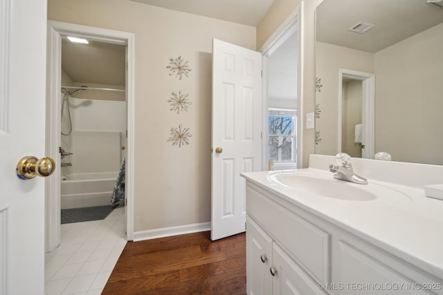 bathroom featuring vanity, bathing tub / shower combination, baseboards, and visible vents