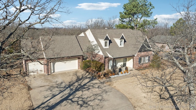 view of front of home with brick siding, driveway, a shingled roof, and a garage