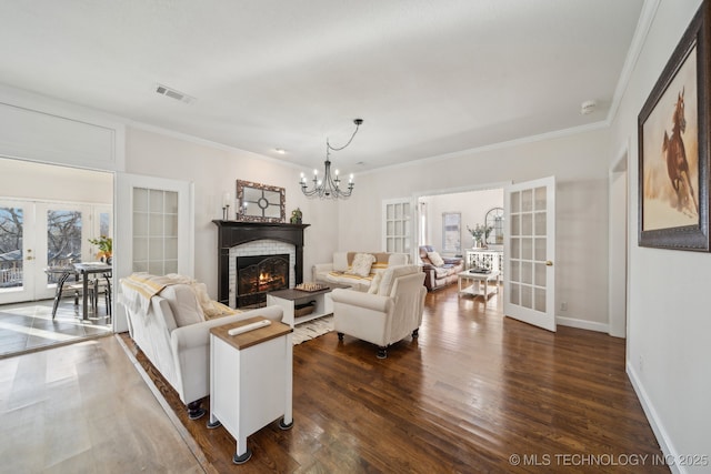 living area with french doors, visible vents, a chandelier, and dark wood-style floors