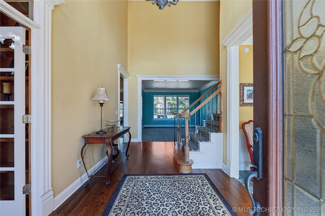 foyer with stairway, baseboards, and wood finished floors