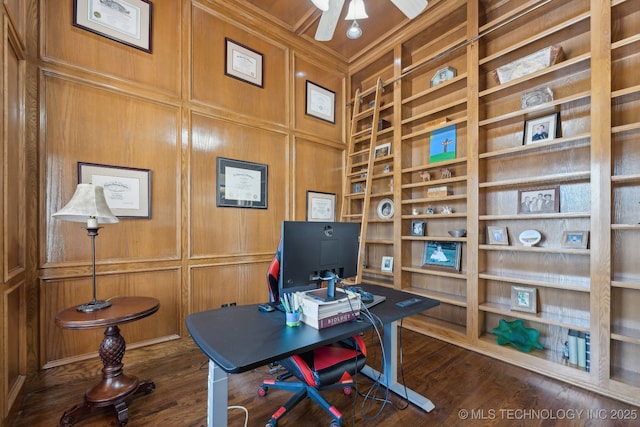 office space with dark wood-type flooring, a decorative wall, and built in shelves