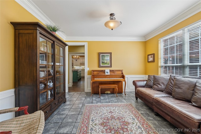 living area with wainscoting and ornamental molding