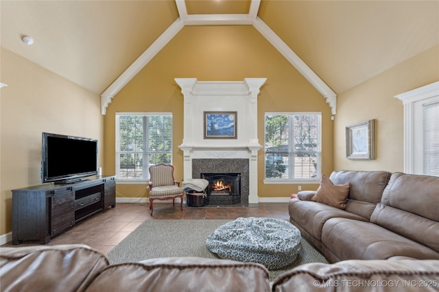 living room featuring tile patterned flooring, a fireplace with flush hearth, baseboards, and high vaulted ceiling